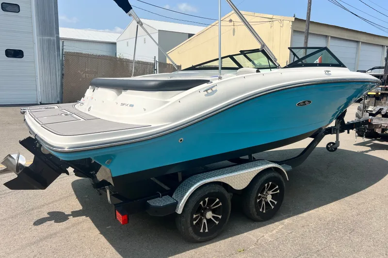 Slide: The Image of 2023 Sea Ray SPX 190 boat on trailer, blue and white design, parked outdoors. - 31