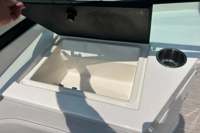 Slide: The Image of 2023 Sea Ray SPX 190 boat compartment with open lid and cup holder. - 28