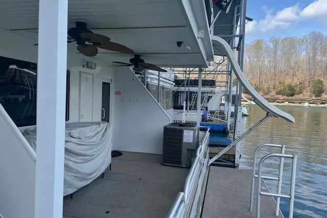 Slide: The Image of Houseboat docked by a lake, featuring outdoor fans and railing, Fantasy 20x100 model, 2006. - 57