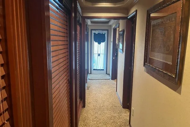 Slide: The Image of A narrow hallway with wooden doors and framed artwork, leading to a door with a curtain. - 31