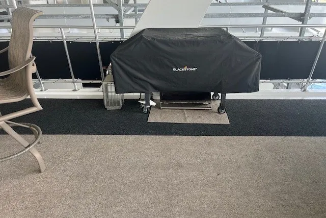Slide: The Image of Covered Blackstone grill on a carpeted patio, adjacent to a chair. - 62