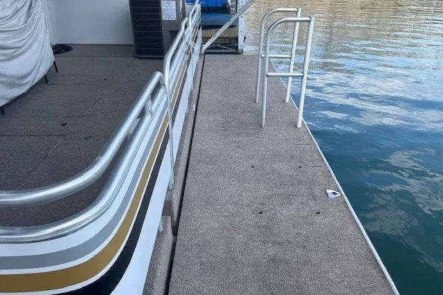 Slide: The Image of A 2006 Fantasy 20x100 houseboat deck with railing, docked on calm water. - 56