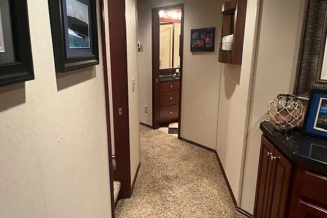 Slide: The Image of Narrow hallway in a 2006 Fantasy 20x100 model, featuring carpet and wooden cabinetry. - 26
