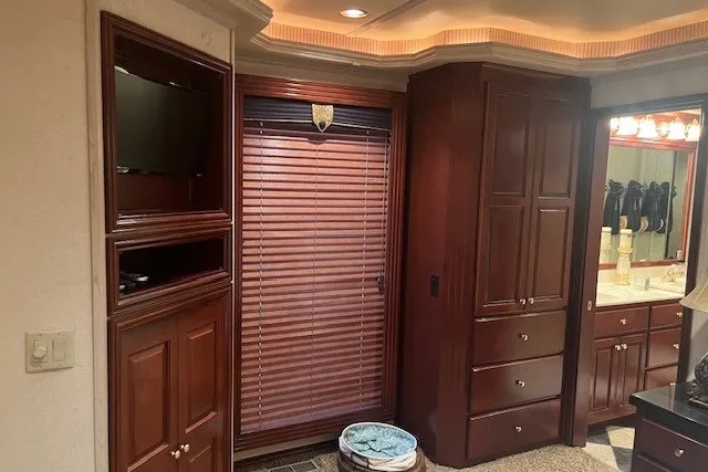 Slide: The Image of Luxurious RV interior with wooden cabinets, blinds, and a glimpse of a bathroom, Fantasy 20x100, 2006. - 48