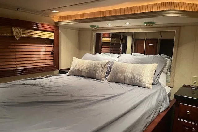 Slide: The Image of Luxurious bedroom interior in a 2006 Fantasy 20x100 model, featuring elegant bedding and wooden accents. - 37