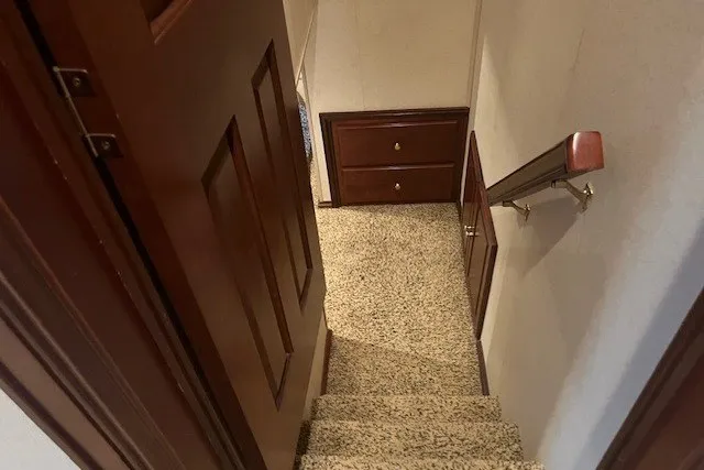 Slide: The Image of Narrow carpeted staircase with wooden handrail and door, inside a Fantasy 20x100 model, 2006. - 44