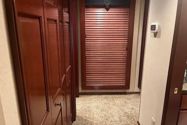 Slide: The Image of Hallway with wooden doors, carpeted floor, and window blinds in a 2006 Fantasy model. - 30