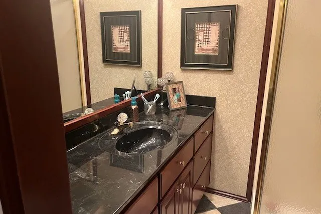 Slide: The Image of Luxurious bathroom with marble countertop, black sink, and elegant framed artwork, Fantasy 20x100, 2006. - 33