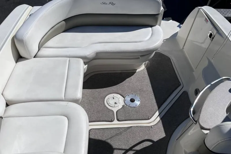 Slide: The Image of 2006 Searay 260 boat interior with white cushioned seating and carpeted floor. - 2