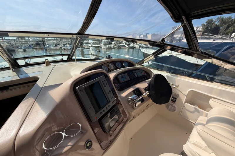 Slide: The Image of Cockpit view of 2003 Sea Ray 380 Sundancer yacht at marina, showcasing controls and navigation equipment. - 13