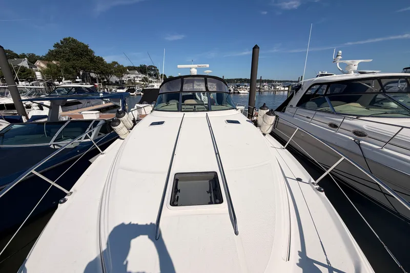Slide: The Image of 2003 Sea Ray 380 Sundancer yacht docked at marina under clear blue sky. - 3