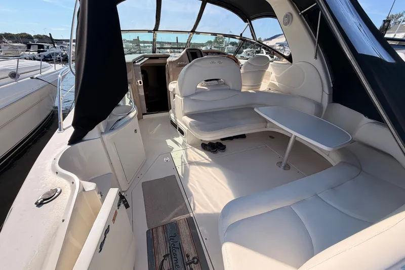 Slide: The Image of 2003 Sea Ray 380 Sundancer boat interior with seating and table, docked at marina. - 9