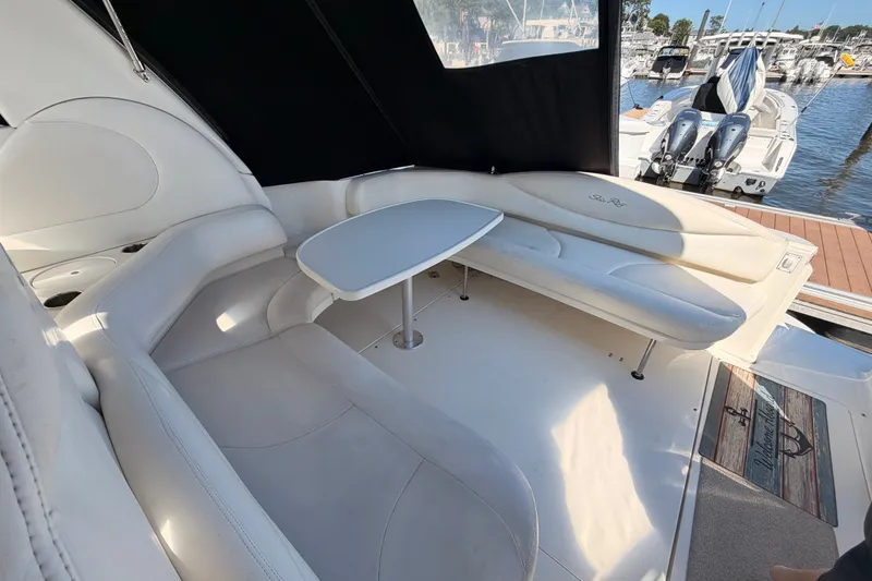 Slide: The Image of Luxurious 2003 Sea Ray 380 Sundancer yacht interior with white seating and table, docked at marina. - 10