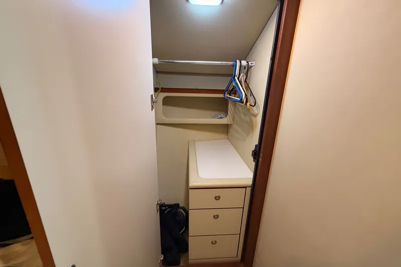 Slide: The Image of Compact closet space in 2003 Sea Ray 380 Sundancer yacht with hangers and drawers. - 24