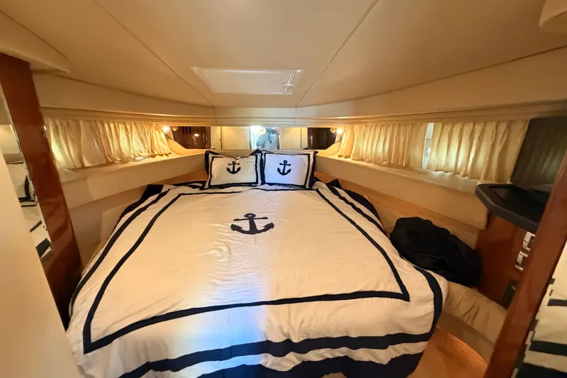 Slide: The Image of Luxurious cabin interior of 2003 Sea Ray 380 Sundancer with nautical-themed bedding. - 18