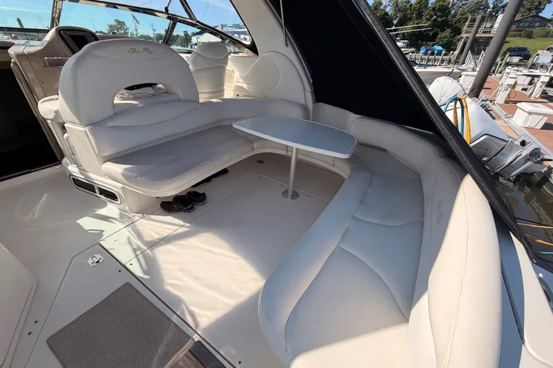 Slide: The Image of 2003 Sea Ray 380 Sundancer interior with white seating and table, docked at marina. - 8