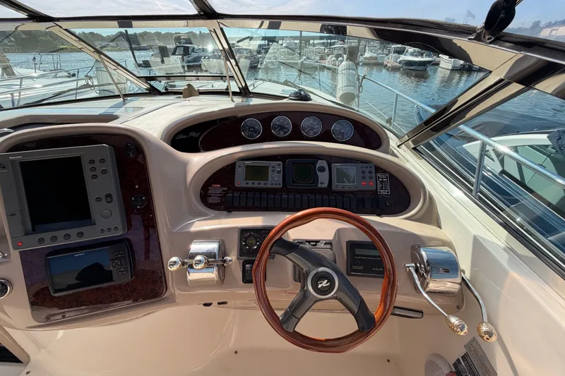Slide: The Image of Cockpit view of 2003 Sea Ray 380 Sundancer with steering wheel and navigation controls. - 14