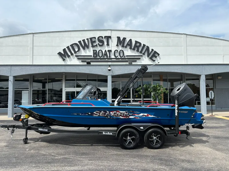 The Image of A blue 2027 SeaArk Protege 200 on a trailer in front of a boat company. - 1