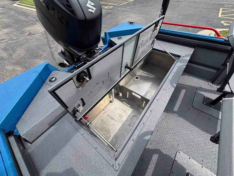 Slide: The Image of An open storage compartment on a 2027 SeaArk Protege 200 boat, featuring an outboard motor. - 22