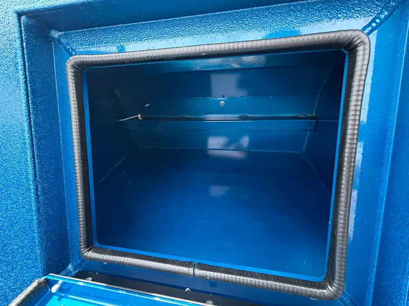 Slide: The Image of An empty blue storage compartment with a padded edge. - 18