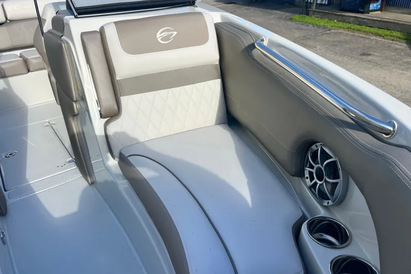 Slide: The Image of 2027 Crownline 200 SS boat interior with gray seating, speaker, and cup holders. - 10