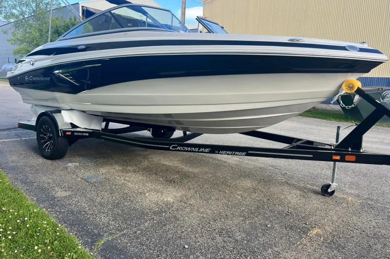 Slide: The Image of 2027 Crownline 200 SS boat on trailer, parked outdoors, showcasing sleek design and modern features. - 3