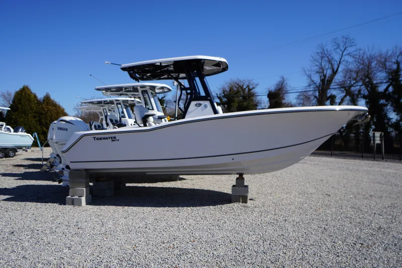 The Image of 2026 Tidewater 232 CC Adventure boat on display in a gravel lot. - 0