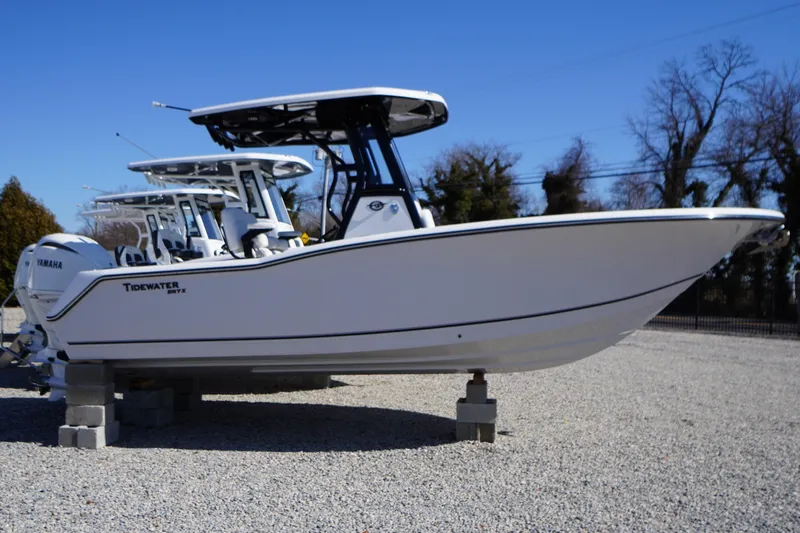 The Image of 2026 Tidewater 232 CC Adventure boat on display in a gravel lot. - 0