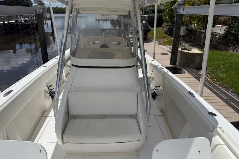 Slide: The Image of 2014 Intrepid 327 Center Console boat docked, featuring spacious seating and sleek design. - 10