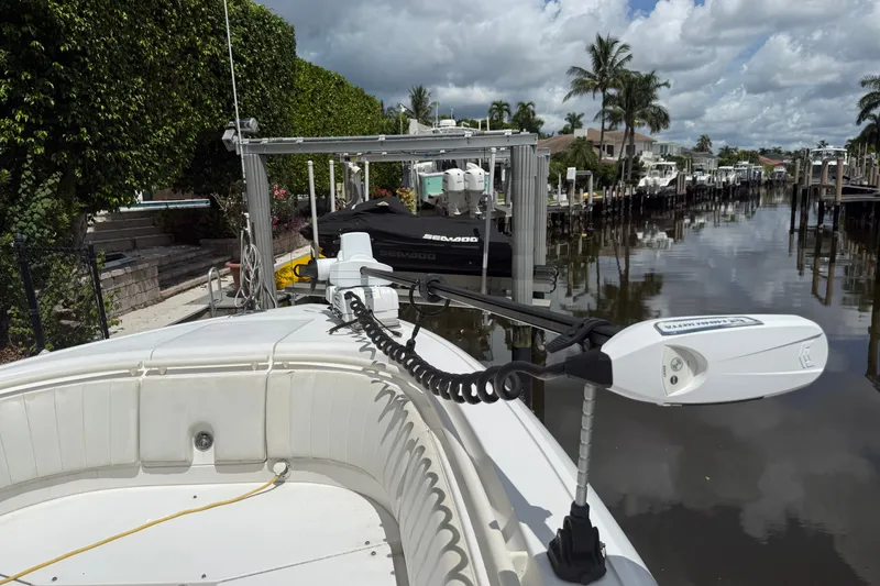 Slide: The Image of 2014 Intrepid 327 Center Console boat docked in a scenic canal setting. - 8