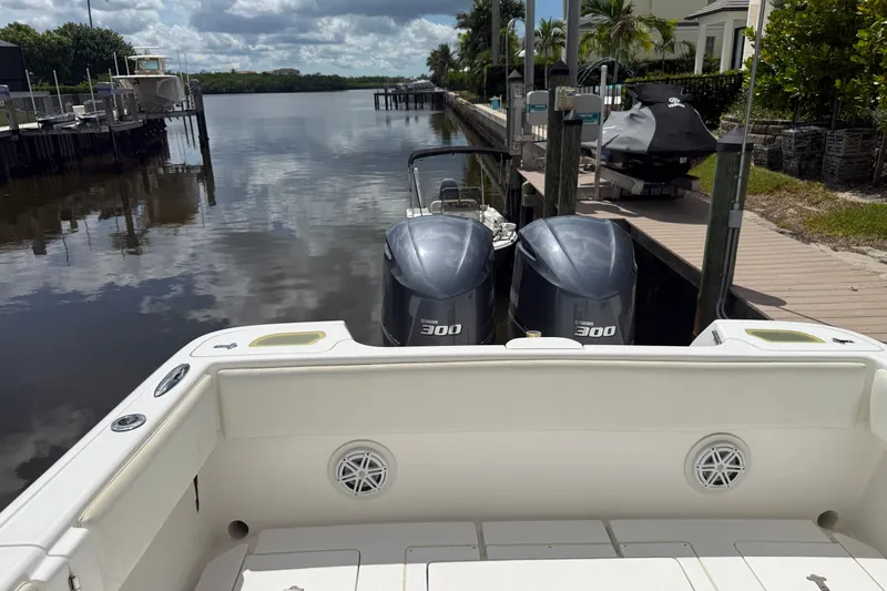Slide: The Image of 2014 Intrepid 327 Center Console boat with twin Yamaha 300 engines docked by a canal. - 19