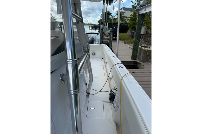 Slide: The Image of 2014 Intrepid 327 Center Console boat docked, showcasing sleek design and spacious deck. - 12