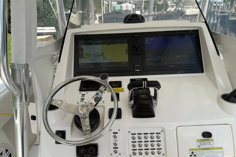 Slide: The Image of 2014 Intrepid 327 Center Console helm with dual Garmin displays and steering wheel. - 22