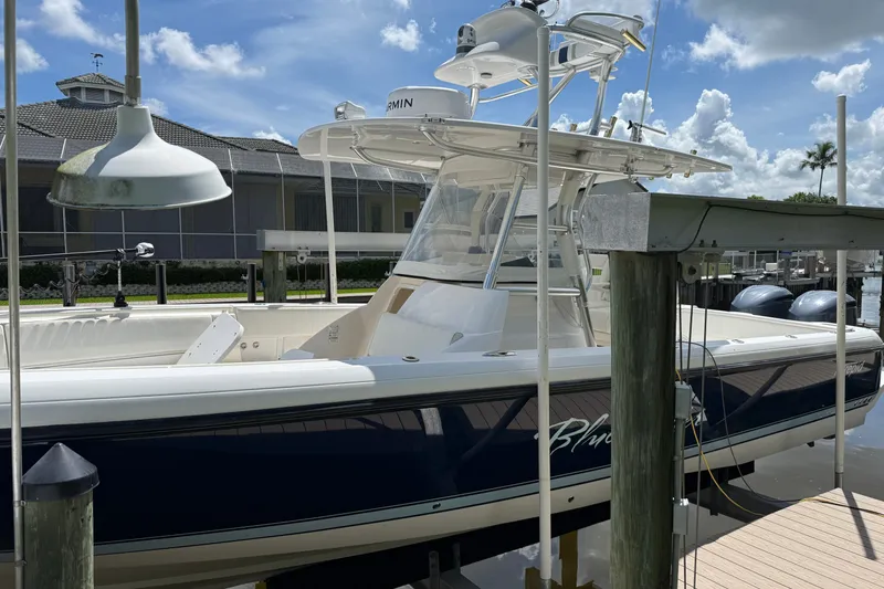 Slide: The Image of 2014 Intrepid 327 Center Console boat docked under a clear blue sky. - 2