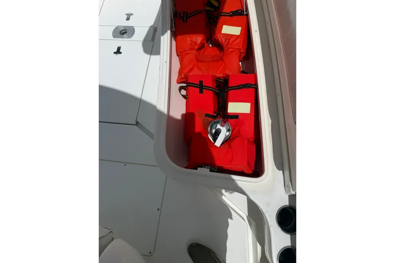 Slide: The Image of Storage compartment with life jackets on a 2014 Intrepid 327 Center Console boat. - 13