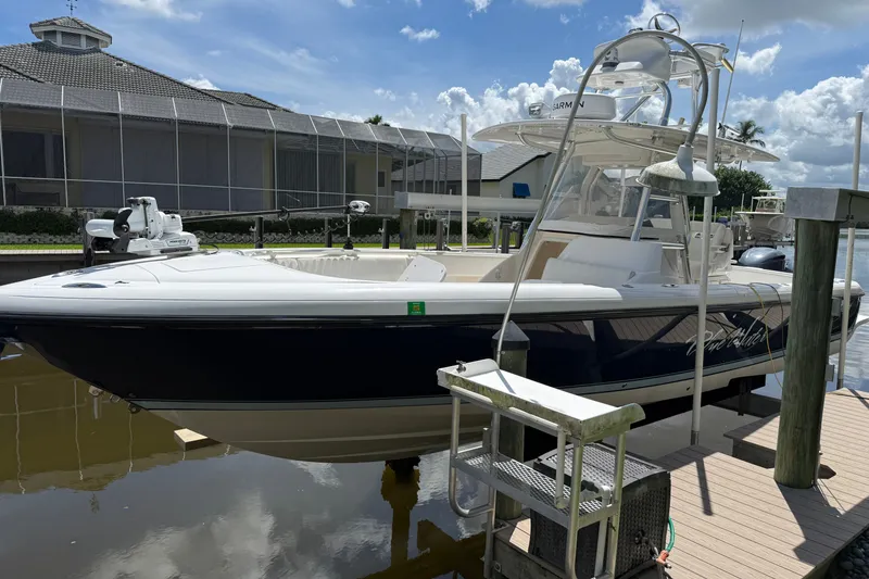 Slide: The Image of 2014 Intrepid 327 Center Console boat docked by waterfront home. - 5