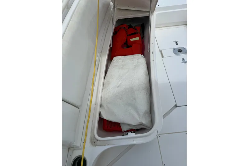 Slide: The Image of Storage compartment on a 2014 Intrepid 327 Center Console boat with life jackets. - 14