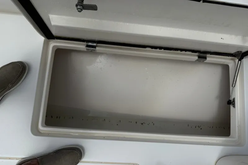 Slide: The Image of Open storage compartment on a 2014 Intrepid 327 Center Console boat. - 17