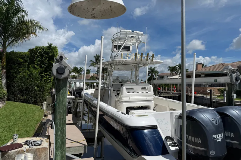 Slide: The Image of 2014 Intrepid 327 Center Console boat docked with Yamaha engines, under a clear blue sky. - 1
