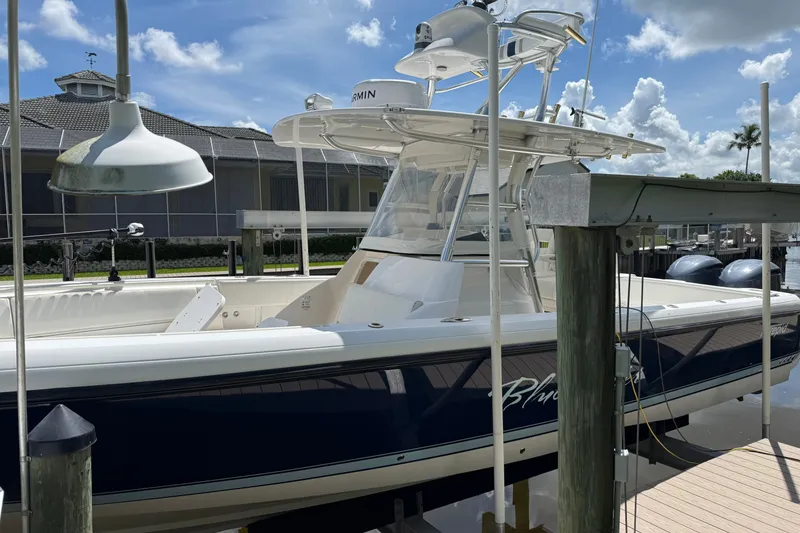Slide: The Image of 2014 Intrepid 327 Center Console boat docked under a clear blue sky. - 3