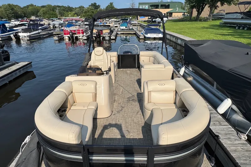 Slide: The Image of 2020 Harris Cruiser 210 pontoon boat docked at marina with beige seating. - 2