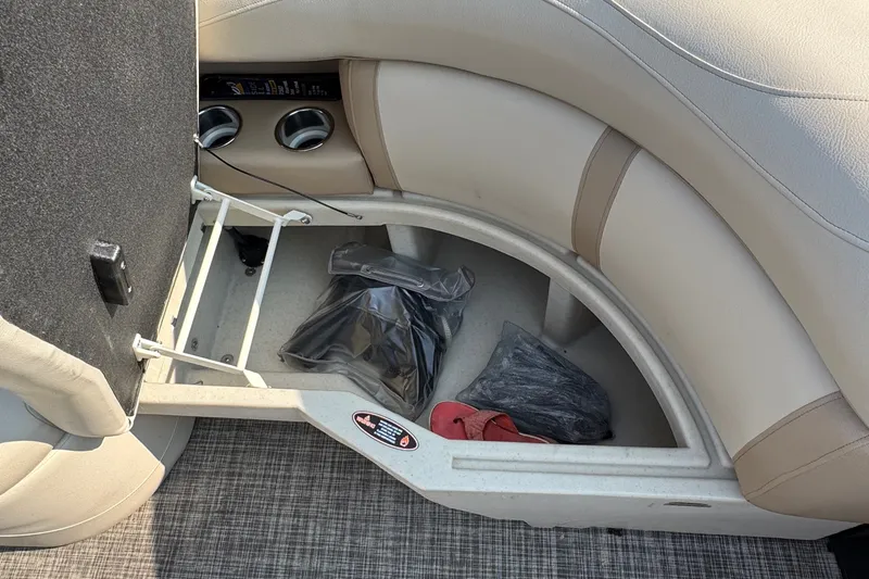 Slide: The Image of Storage compartment in a 2020 Harris Cruiser 210 boat with cup holders and items inside. - 9
