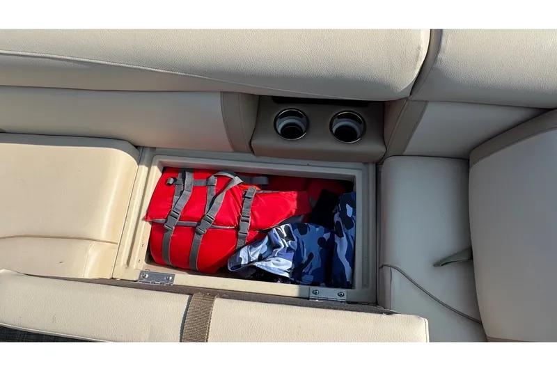 Slide: The Image of A seating area with storage underneath, containing a red life jacket and blue clothing. - 11