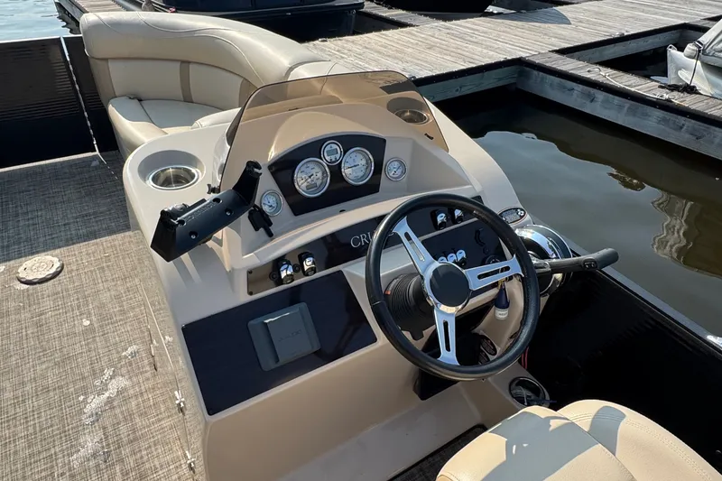 Slide: The Image of 2020 Harris Cruiser 210 boat dashboard with steering wheel and gauges at marina. - 7
