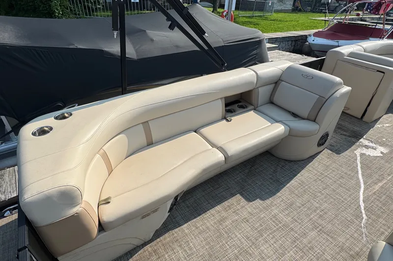 Slide: The Image of 2020 Harris Cruiser 210 boat with beige seating and cup holders on deck. - 6