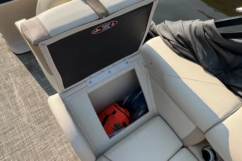 Slide: The Image of Open storage compartment on a 2020 Harris Cruiser 210 boat with beige seating. - 13