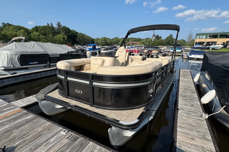 The Image of 2020 Harris Cruiser 210 pontoon boat docked at a marina under a clear blue sky. - 0
