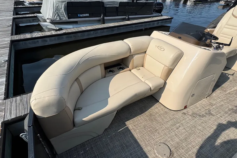 Slide: The Image of 2020 Harris Cruiser 210 boat with beige seating at a marina dock. - 3