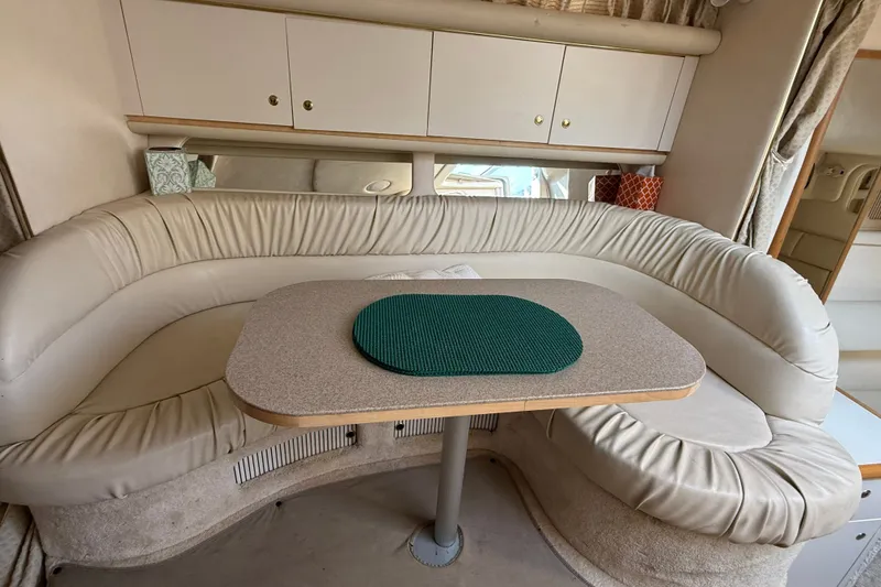 Slide: The Image of Interior of a 2000 Sea Ray 340 Sundancer with a curved leather seating area and table. - 16