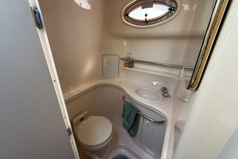Slide: The Image of Compact bathroom in 2000 Sea Ray 340 Sundancer yacht with sink, toilet, and porthole window. - 19